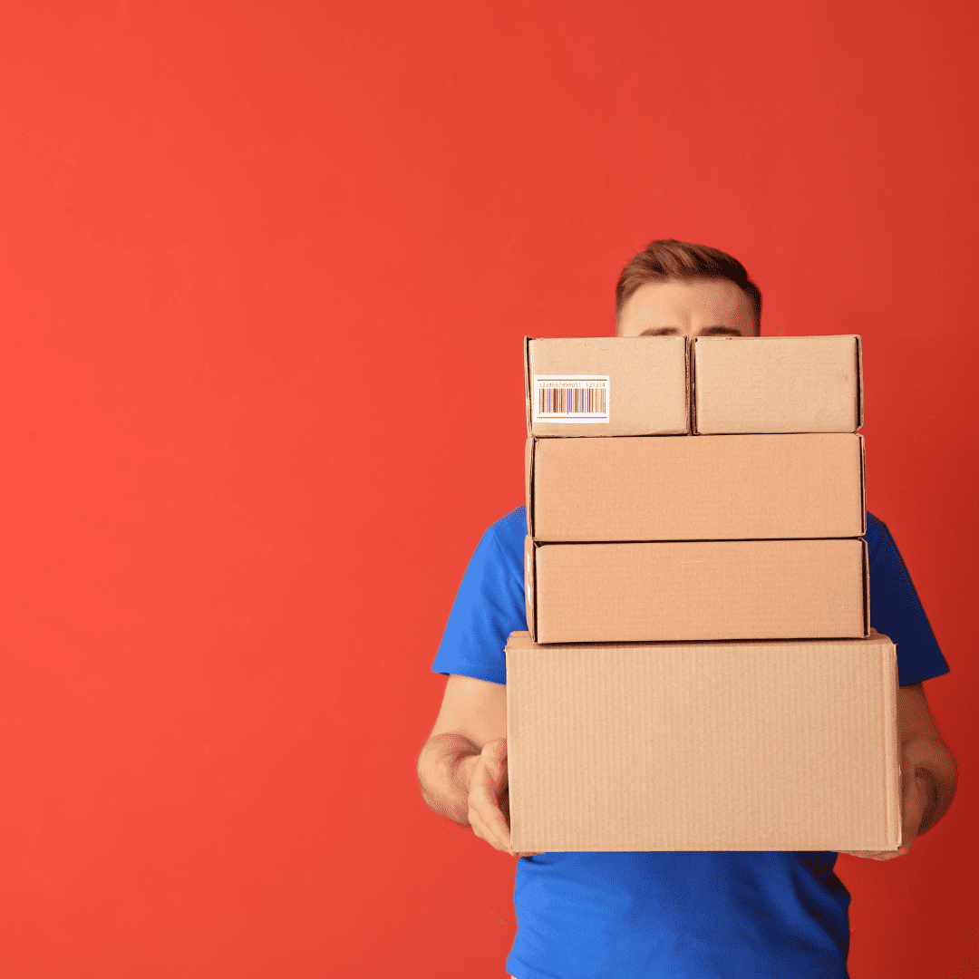 man holding delivery boxes against a red background