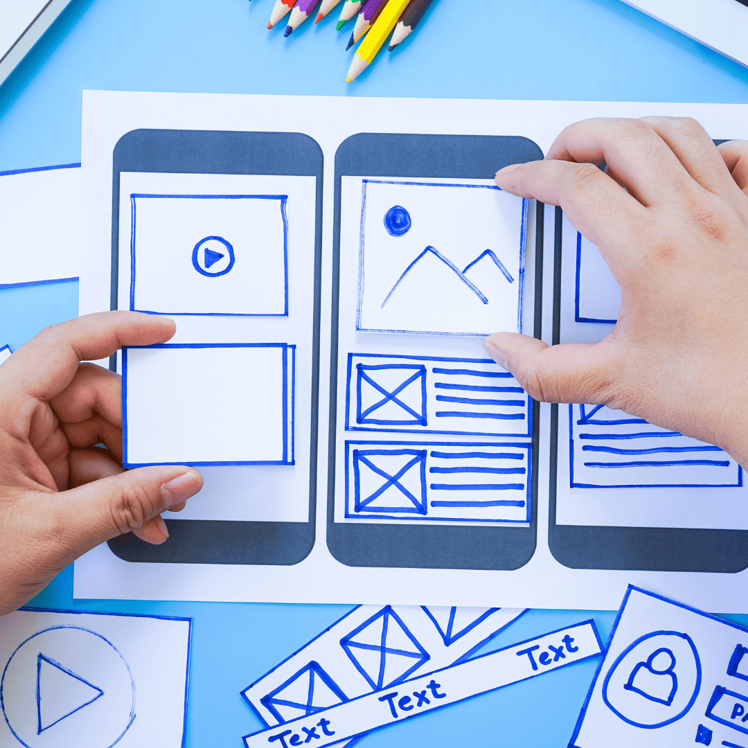 a website designer sorting wireframe screens for mobile application