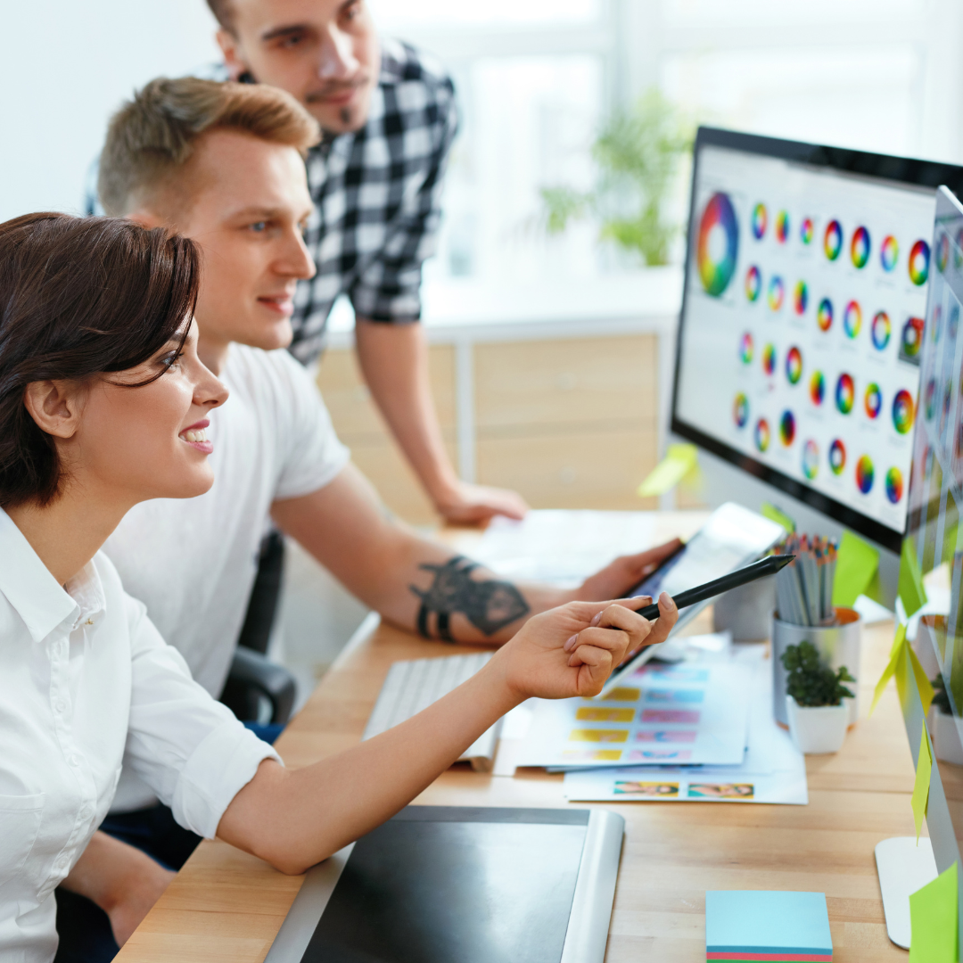 A group of web designers looking at a computer screen at their BigCommerce web designs and graphics