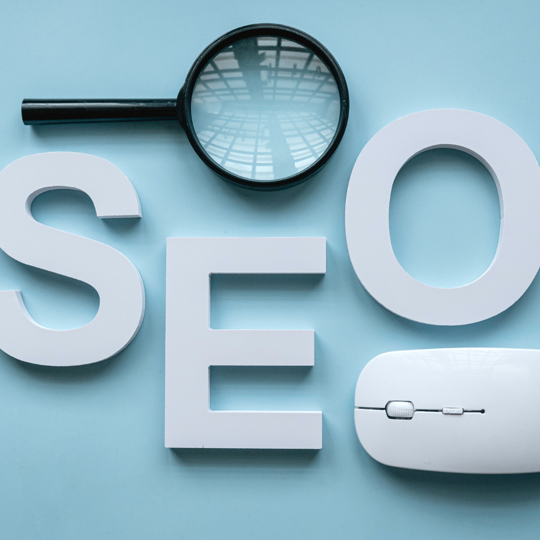 BigCommerce seo services depicted by a magnifying glass on top of blocks spelling "SEO" and a mouse.