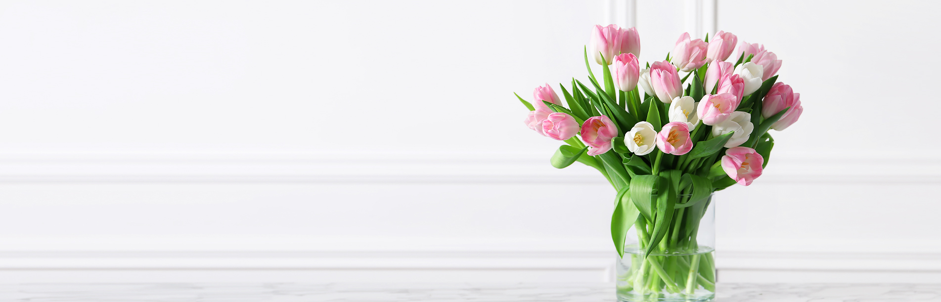 Nebula Beauty & Home banner featuring pink and white tulips with green leaves on a clean white background.