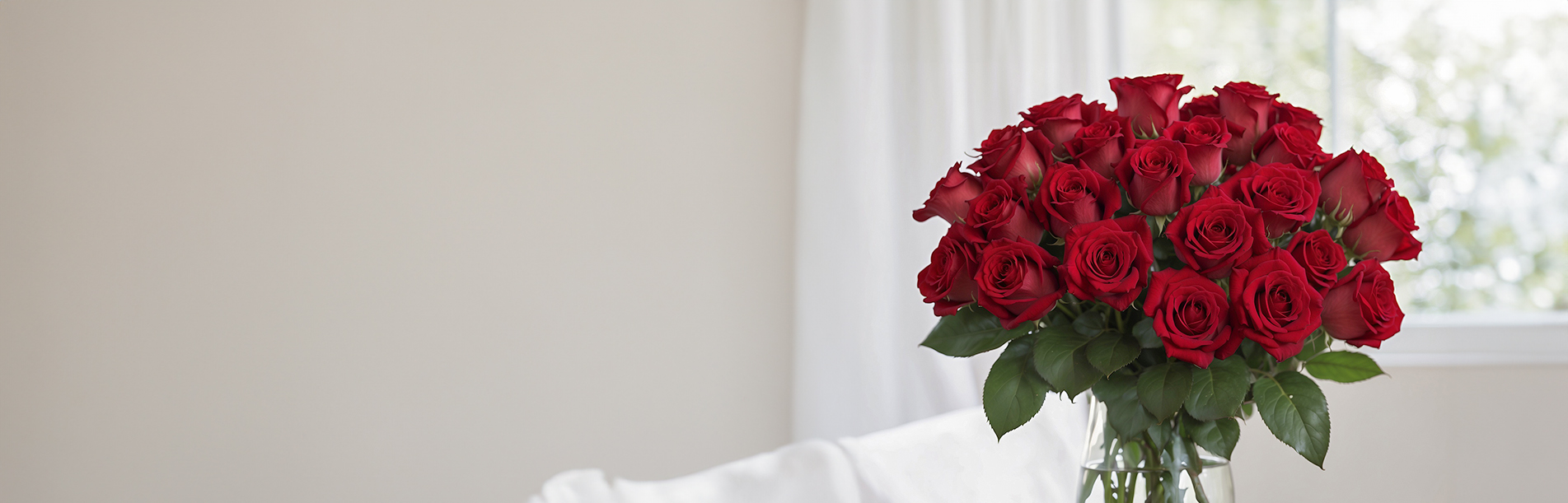 Nebula Beauty & Home banner featuring Large bouquet of red roses in a glass vase indoors near a bright window; classic romantic arrangement.