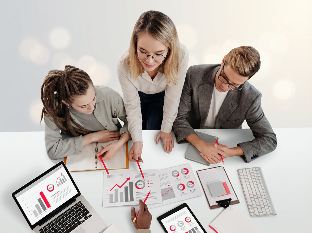 Business team collaborating on data analysis, examining performance charts and graphs during a strategy meeting.